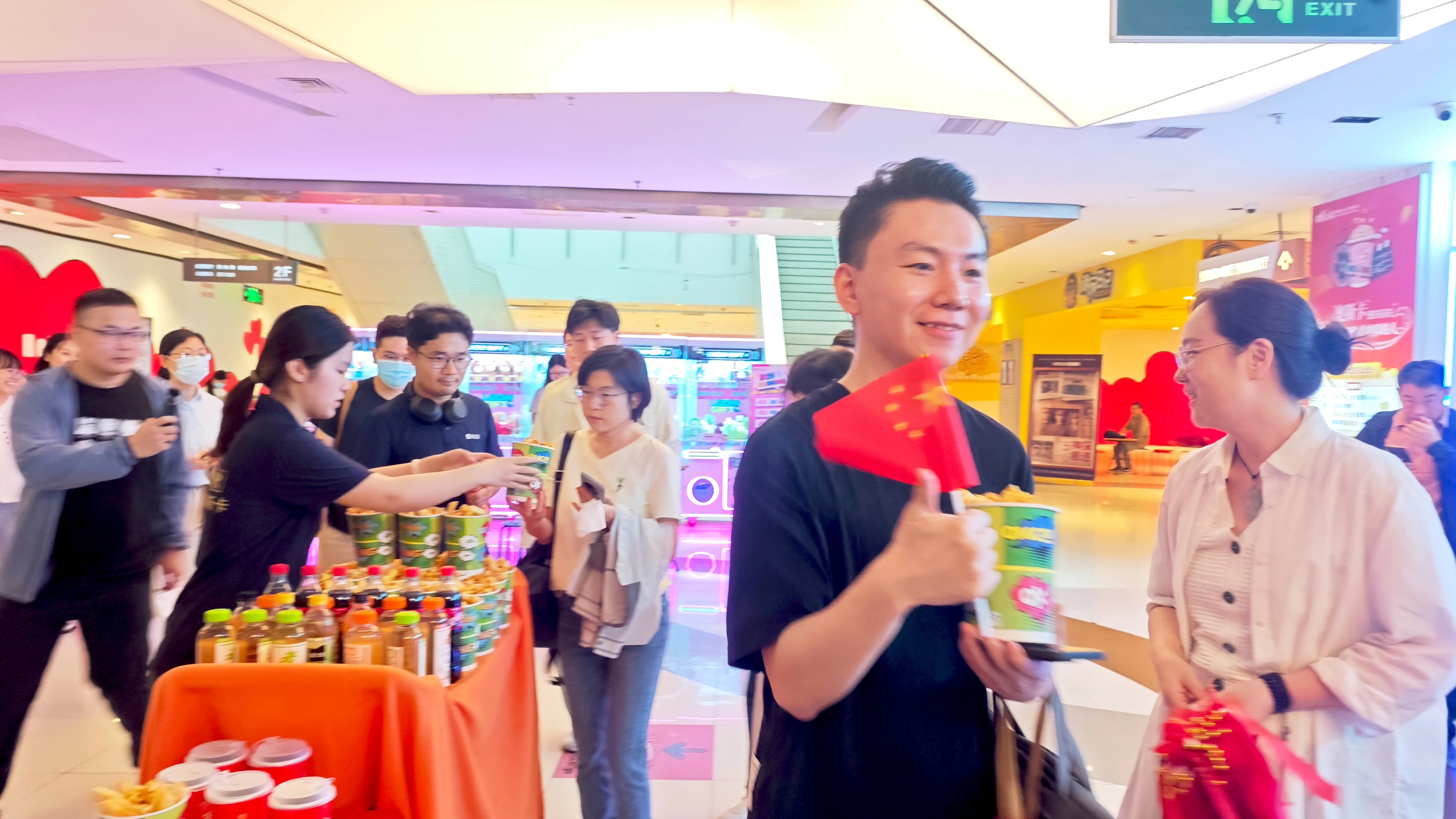 亚建科技员工到达影院，手持小红旗与爆米花准备入场。